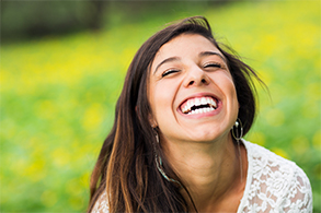 Laughing woman with flawless smile outdoors
