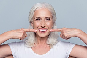 Senior woman pointing to flawless smile